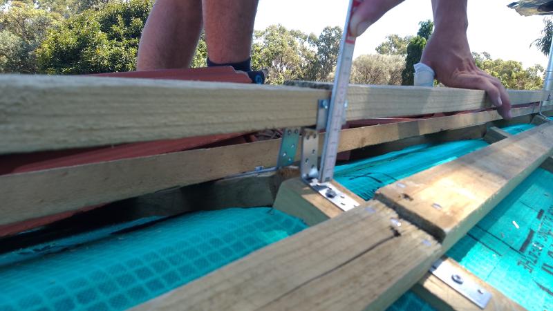 The ridge caps are bolted onto a ridge-batten. The brackets are part of the Rapid Ridge system.