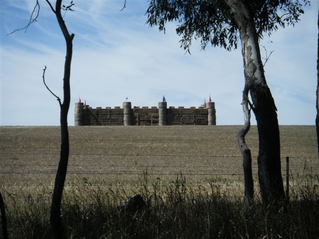 eine Burg??<br>                            <br>Mitten in Australien eine mittelalterliche Burg? <br>Nein - hier hat offensichtlich ein Farmer die Strohballenn"nur" zu einer solchen aufgeschlichtet - <br>und sogar mit Fahnen vesehen. &#160;